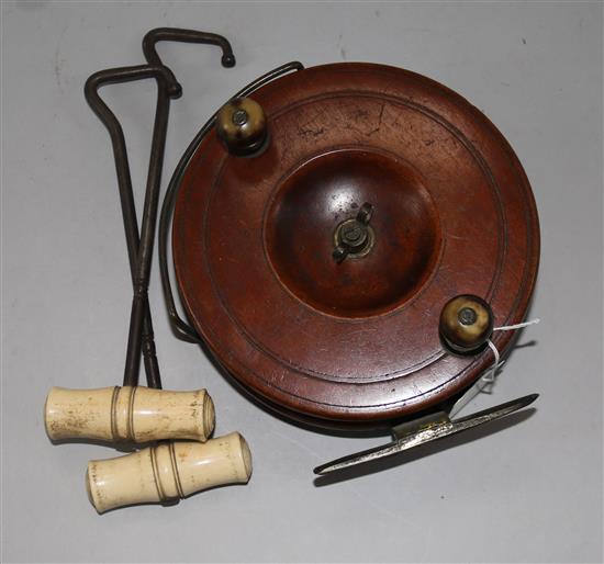An early 20th Century mahogany fishing reel and two bone and steel boat pulls